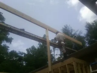 Carpenter setting a ridge beam over a new addition frame — Ice Dam Removal by Roofing Brothers in Ypsilanti