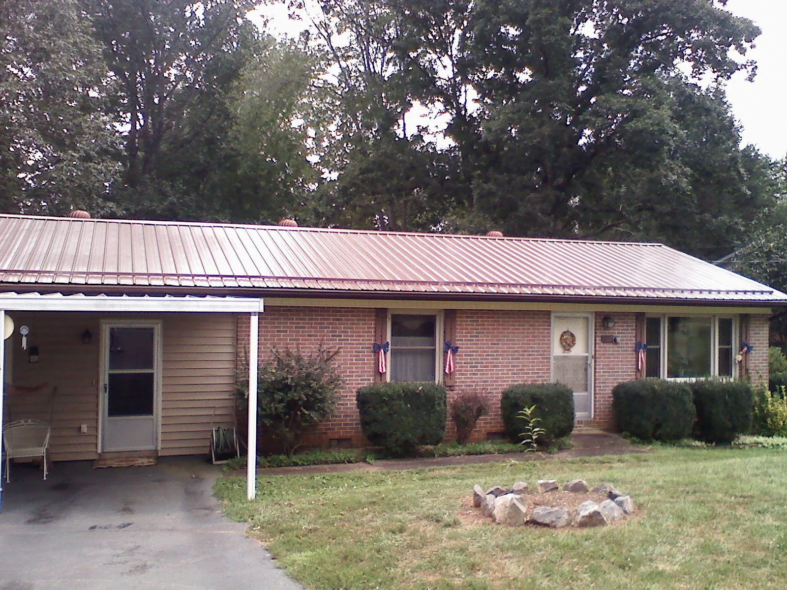 Bronze metal roof and carport on a brick ranch home — Roof Repair work by our crew in Ypsilanti